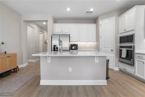 a kitchen with stainless steel appliances a refrigerator sink and microwave