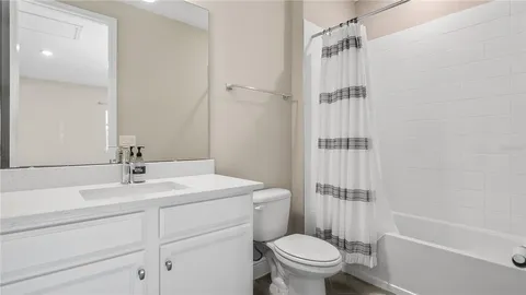 a bathroom with a sink toilet vanity and shower