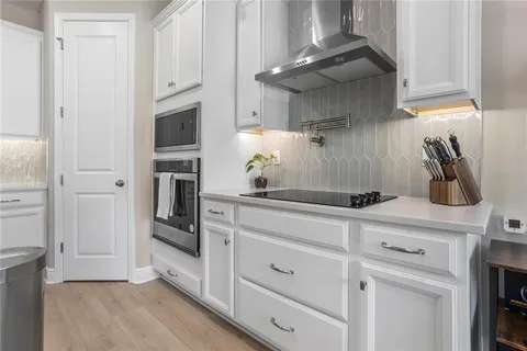 a kitchen with white cabinets and stainless steel appliances