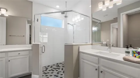 a bathroom with a double vanity sink mirror and shower
