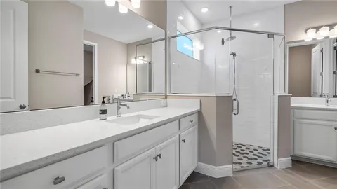 a bathroom with a double vanity sink mirror and shower