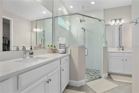 a bathroom with a double vanity sink mirror and shower