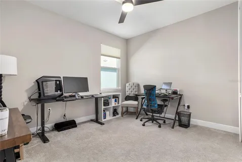 a view of a workspace with furniture and a window