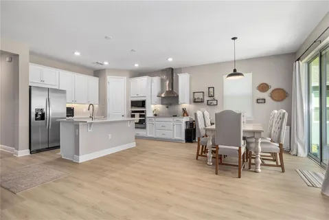 a large white kitchen with lots of furniture and appliances