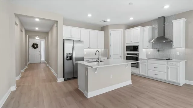 a kitchen with white cabinets and stainless steel appliances
