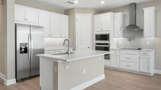 a kitchen with white cabinets and stainless steel appliances