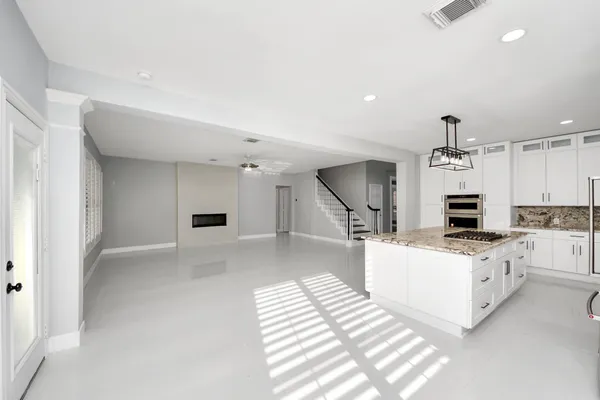 a kitchen with stainless steel appliances granite countertop a refrigerator a stove a sink and a refrigerator