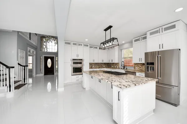 a kitchen with a table chairs refrigerator and microwave