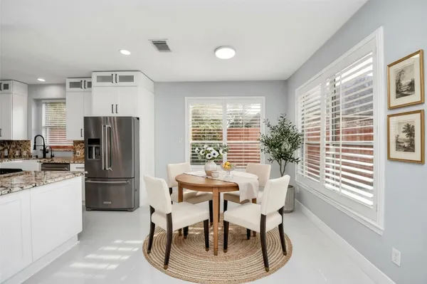 a kitchen with stainless steel appliances kitchen island granite countertop a stove and white cabinets