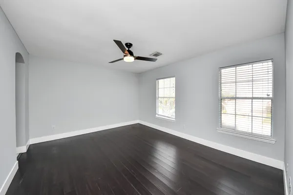 a view of an empty room with wooden floor