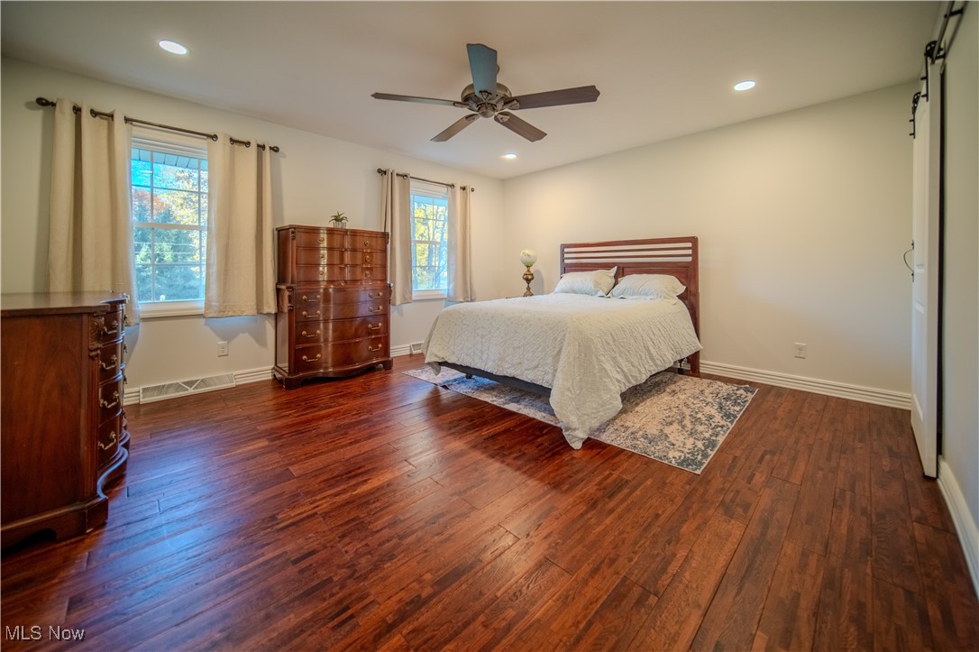 1394 Saxe Road Mogadore, OH 44260 - Photo 25 of 39 Bedroom featuring dark wood finished floors, ceiling fan, recessed lighting, and a barn door