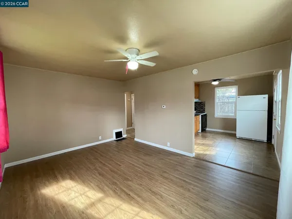 wooden floor in an empty room with a kitchen
