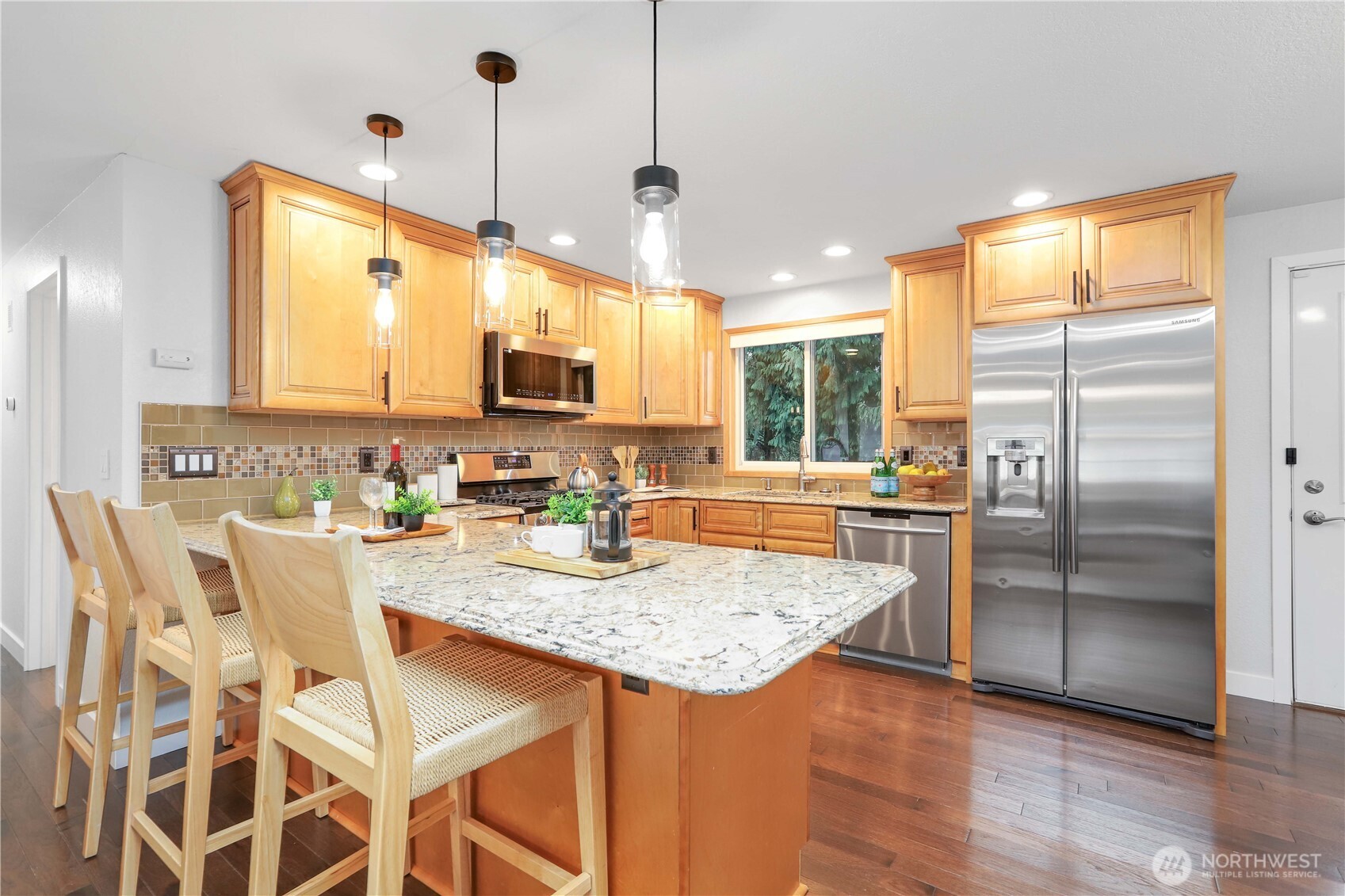 1822 171st Place Southeast Bothell, WA 98012 - Photo 5 of 36 a kitchen with granite countertop a refrigerator a stove a sink cabinetry and a dining table