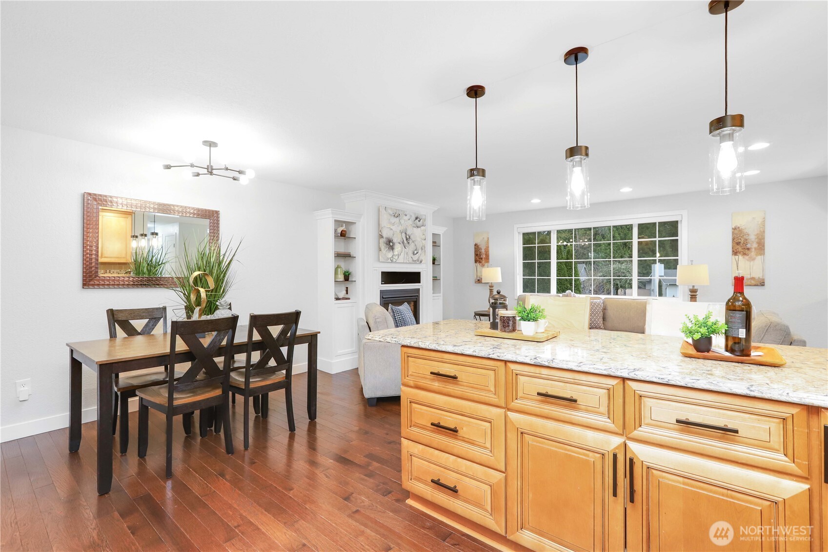 1822 171st Place Southeast Bothell, WA 98012 - Photo 7 of 36 a kitchen with kitchen island a stove a dining table chairs and white cabinets