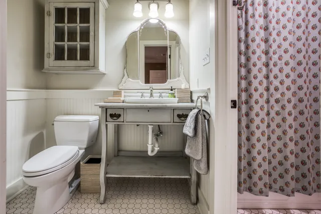 a bathroom with a toilet a sink and a mirror