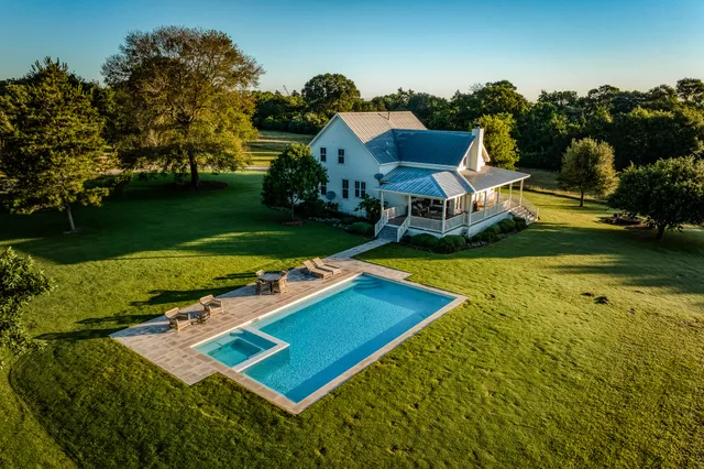 an aerial view of a house with swimming pool garden and outdoor seating