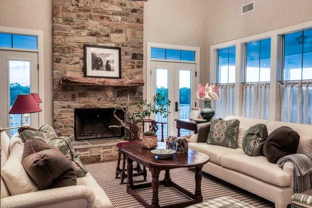 a living room with furniture a fireplace and a large window