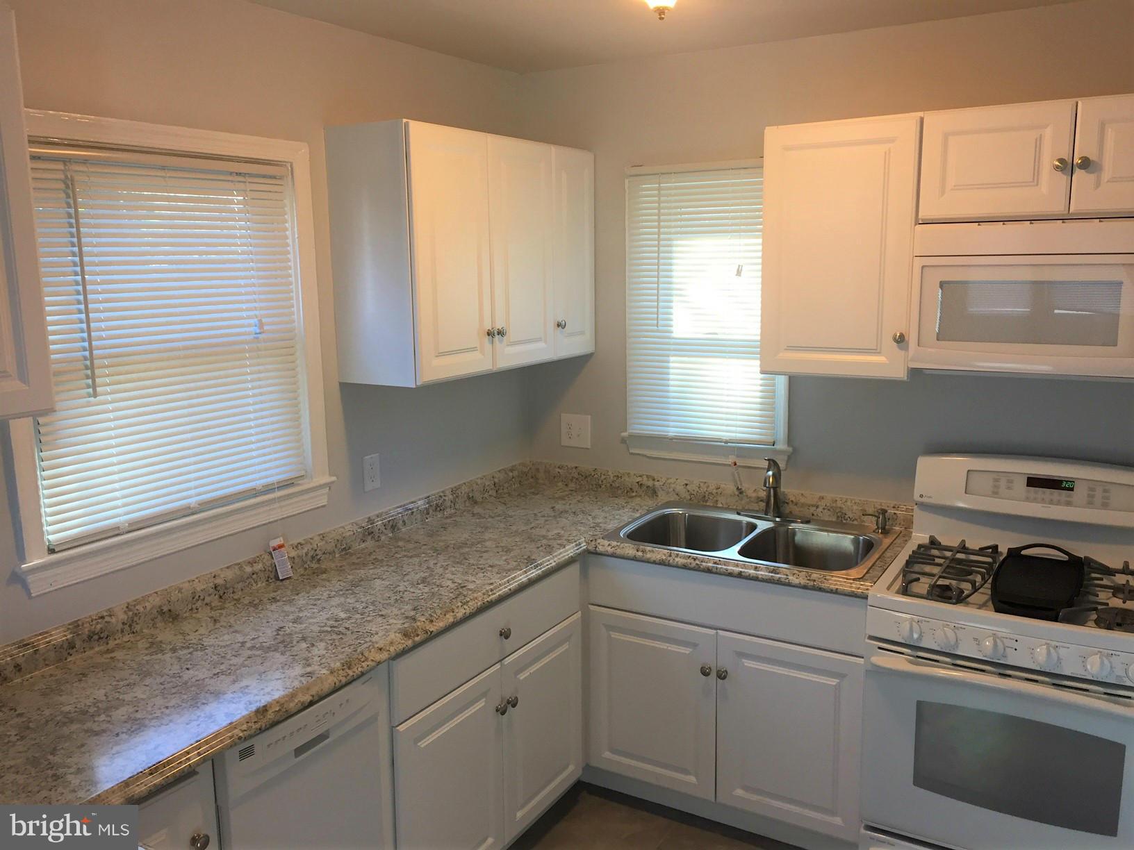 301 East Braddock Road Alexandria, VA 22301 - Photo 7 of 29 a kitchen with white cabinets and a window