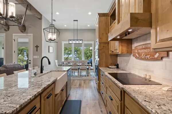 a kitchen with granite countertop a sink a counter top space stainless steel appliances and cabinets