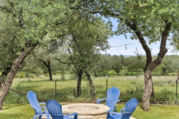 a view of a house with a yard patio and fire pit