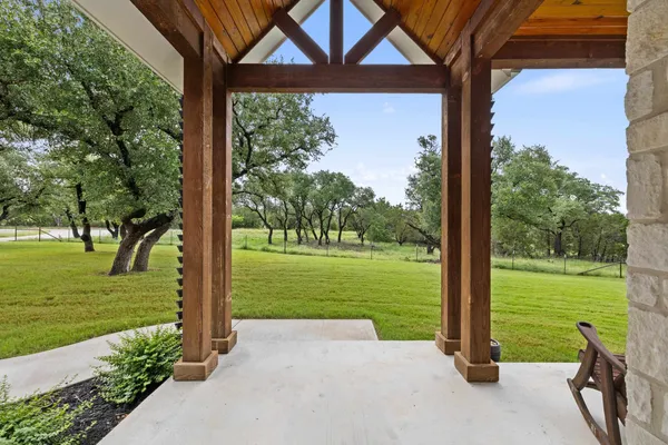 a view of a patio with a table chairs and a yard