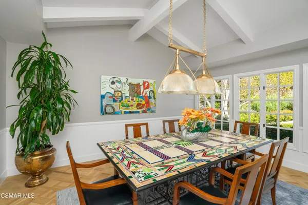 a view of a dining room with furniture a rug and wooden floor