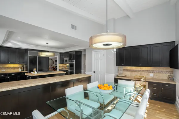 a kitchen with stainless steel appliances granite countertop wooden floor a stove and a refrigerator