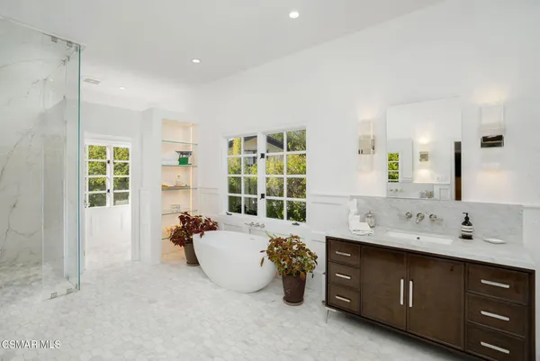 a bathroom with a tub sink and mirror