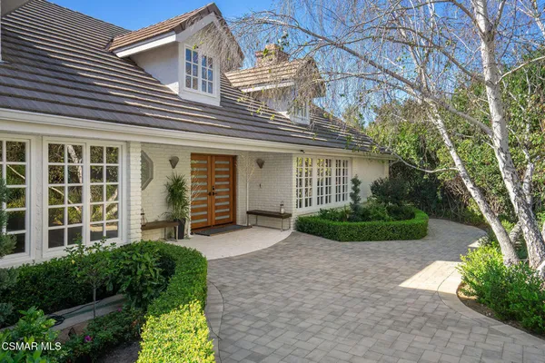 a front view of a house with garden and plants