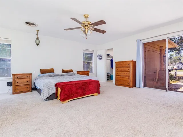 a bedroom with a bed and ceiling fan