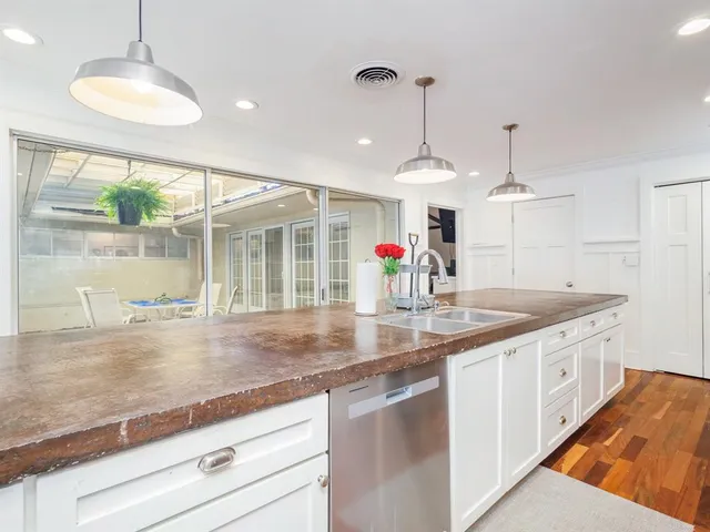 a kitchen with stainless steel appliances granite countertop a sink a counter space and a wooden cabinets