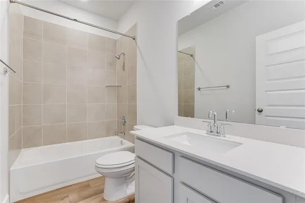 a bathroom with a shower sink vanity mirror and toilet