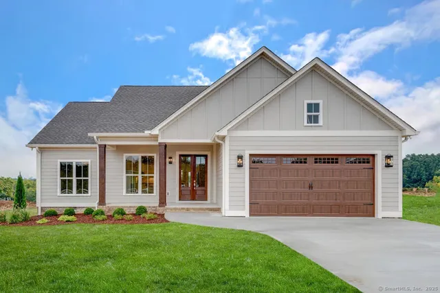 a front view of a house with a garden and yard