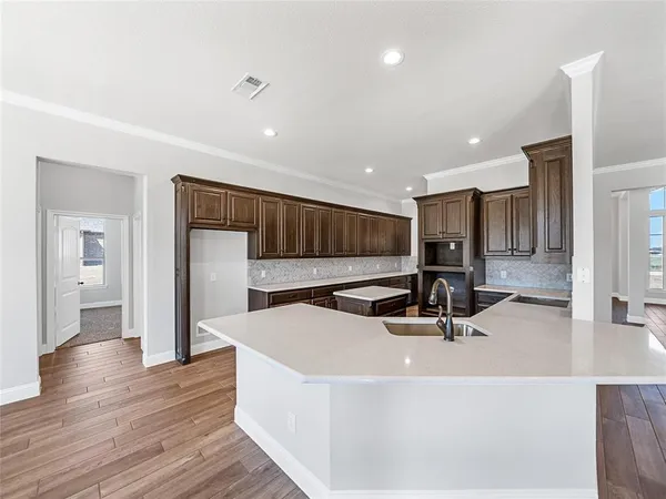 a view of a living room a kitchen island wooden floor and kitchen