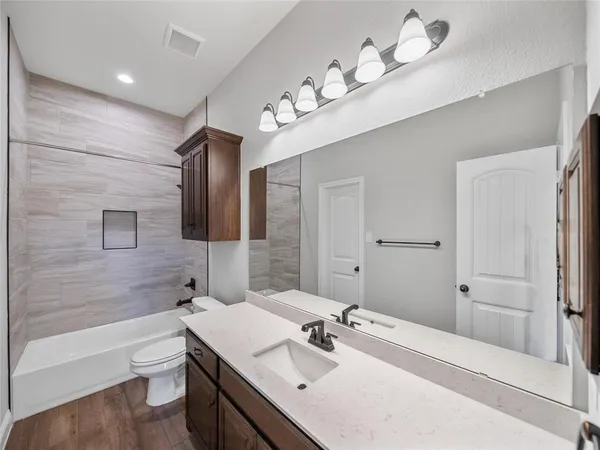 a bathroom with a bathtub a sink and a large mirror