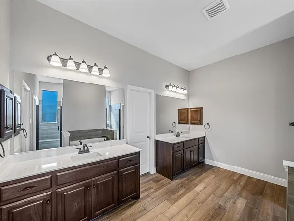 a spacious bathroom with a double vanity sink and mirror