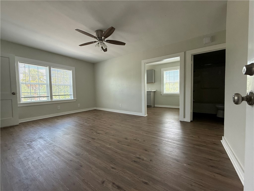 210 O'Neal Avenue, Unit A Sinton, TX 78387 - Photo 3 of 15 wooden floor in an empty room with a window