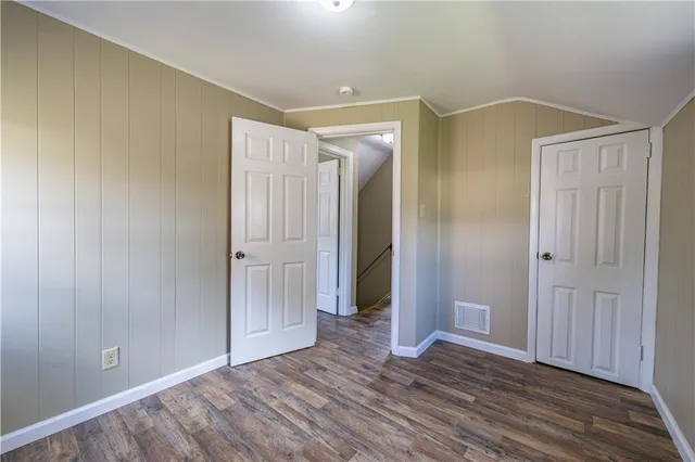 an empty room with closet and wooden floor