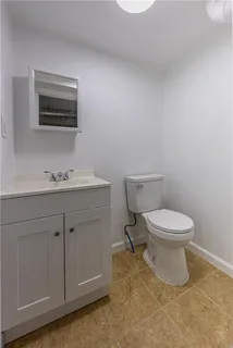 a bathroom with a toilet a sink and mirror