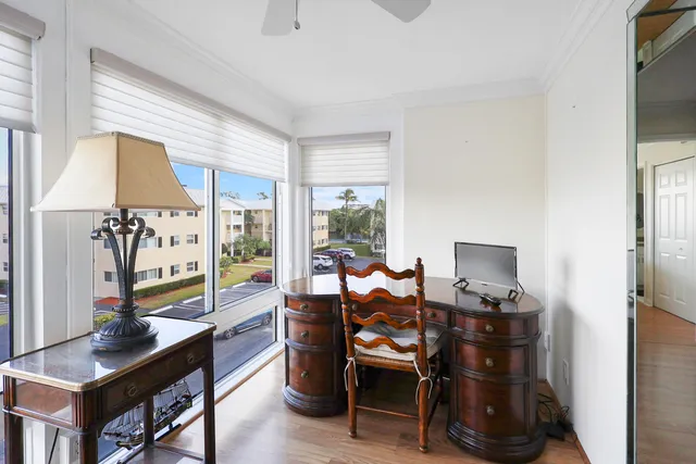 a view of a workspace with furniture and a window