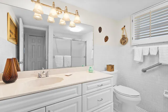 a bathroom with a sink a toilet and mirror