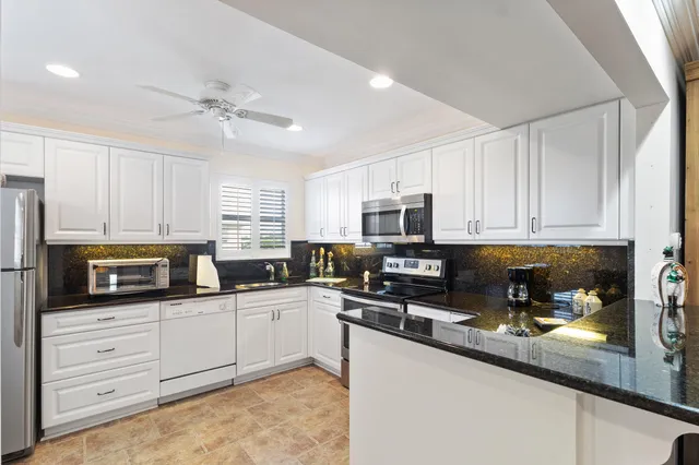 a kitchen with stainless steel appliances a sink a stove cabinets and a refrigerator