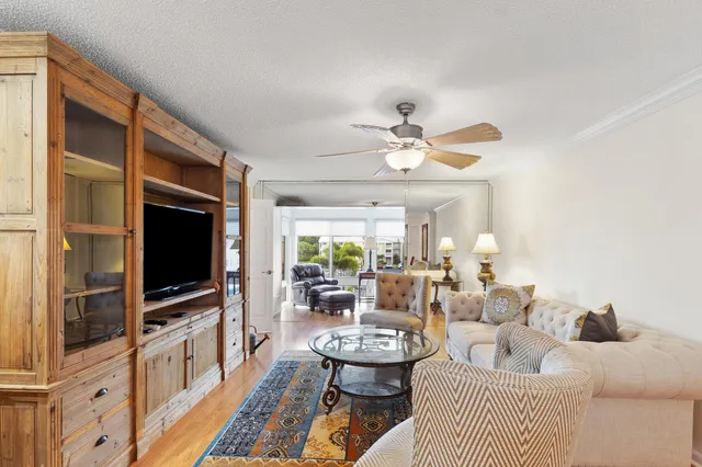 a living room with furniture a flat screen tv and a large window