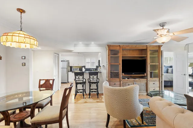 a living room with furniture a flat screen tv and kitchen view