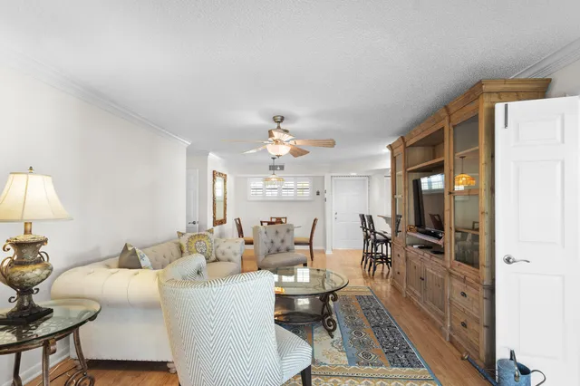 a living room with furniture a chandelier and a flat screen tv