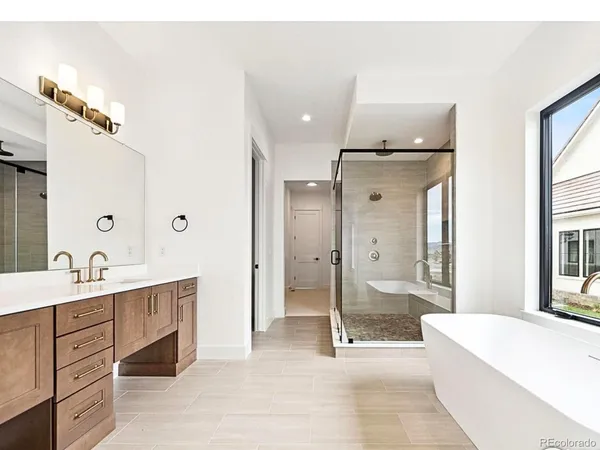 a spacious bathroom with a double vanity sink toilet mirror and bathtub