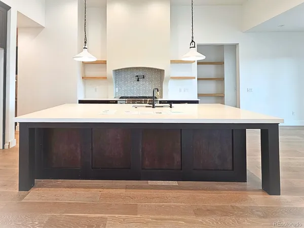 a view of a kitchen with kitchen island sink and refrigerator