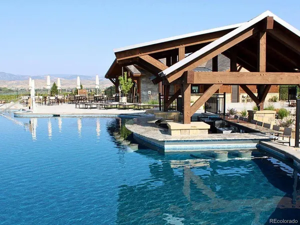 a view of a house with pool and chairs