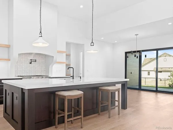 a kitchen with kitchen island a stove a table a sink and cabinets