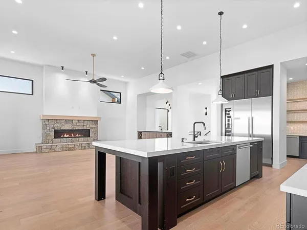 a kitchen with kitchen island a sink stove and refrigerator